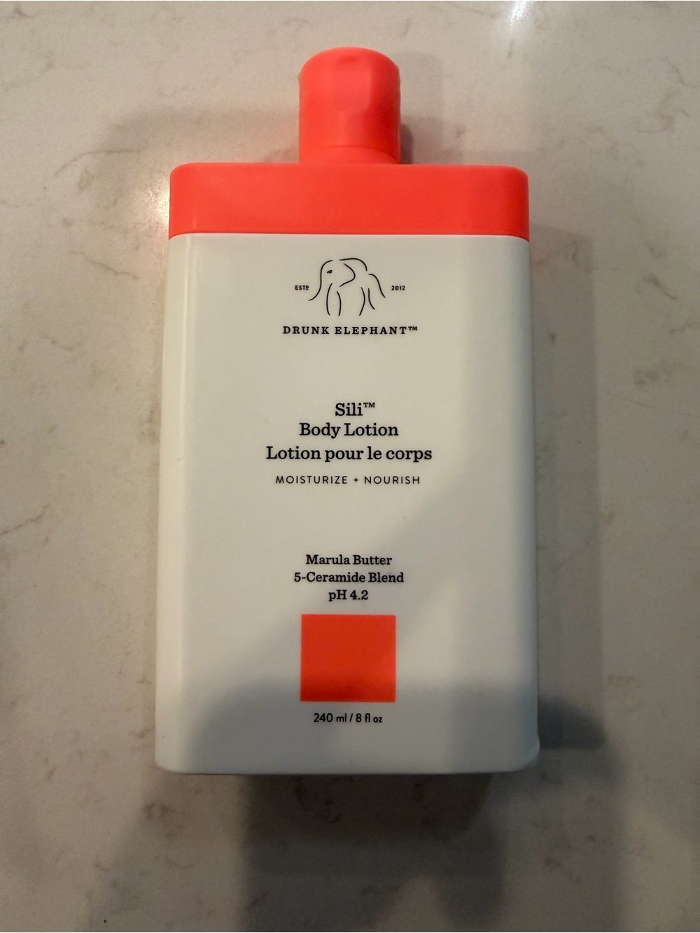 Drunk Elephant Body Lotion in White with Coral Accents